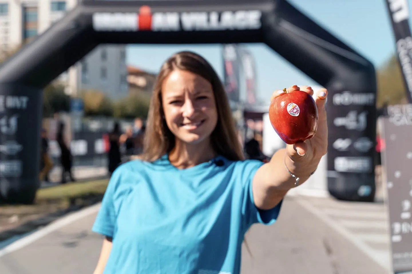 Atleta con una mela brandizzata sponsor al village